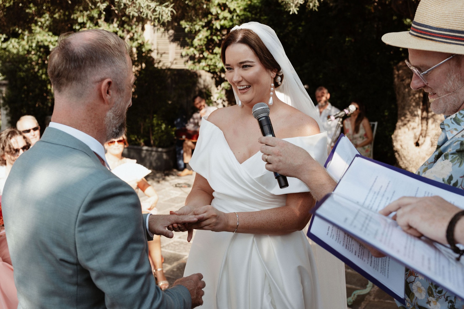 Róisín placing the ring on Ken's hand, microphone in hand