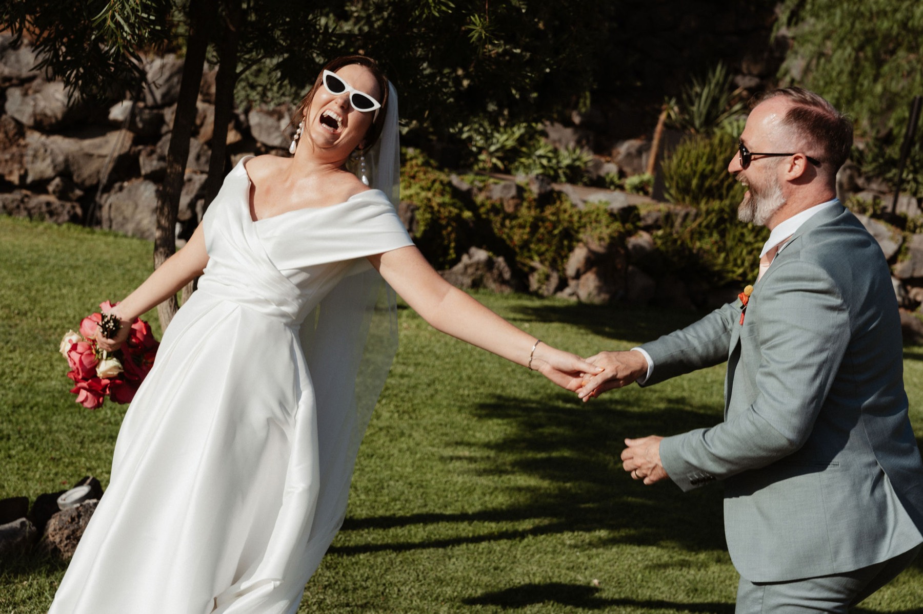 Just married, Róisín and Ken running hand in hand across the lawn
