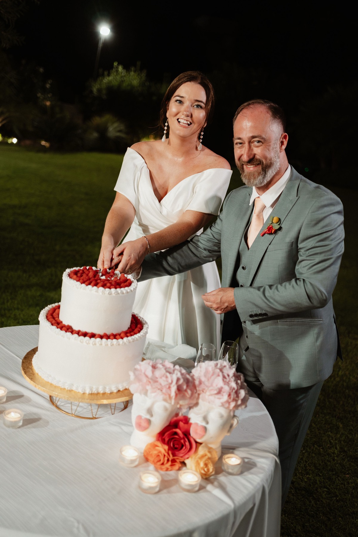 Róisín and Ken cutting the raspberry-trimmed cake