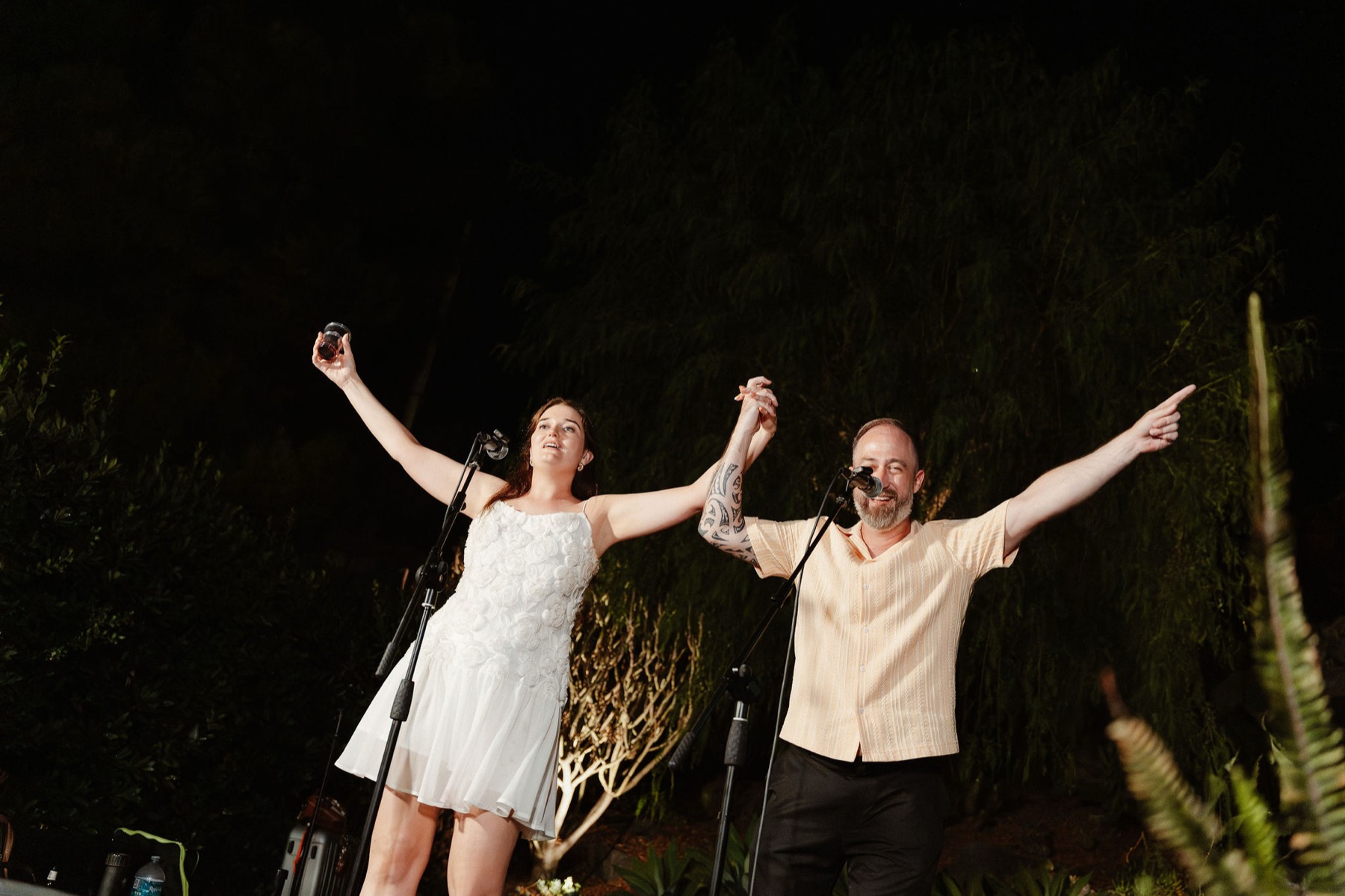 Róisín and Ken on stage, arms raised, the final night